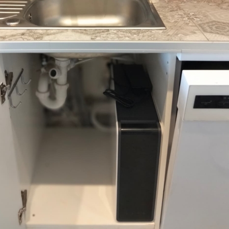 Kompaktowy filtr do wody zamontowany w szafce u klienta FITaqua Hydrion MNX